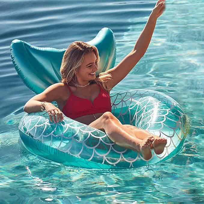 A woman in the water on an inflatable raft.