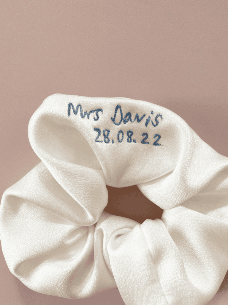 A white scrunchie with the name of mrs. Davis and date 2 8. 0 8. 2 2