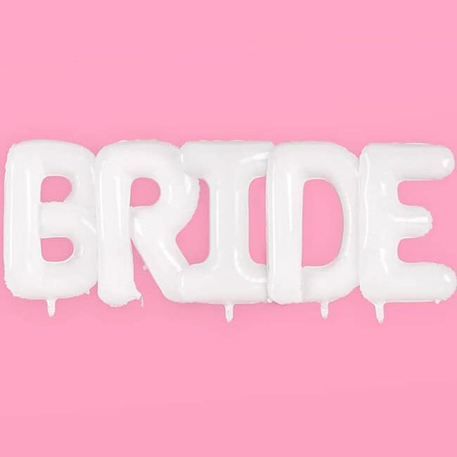 A pink background with white balloons that say bride.