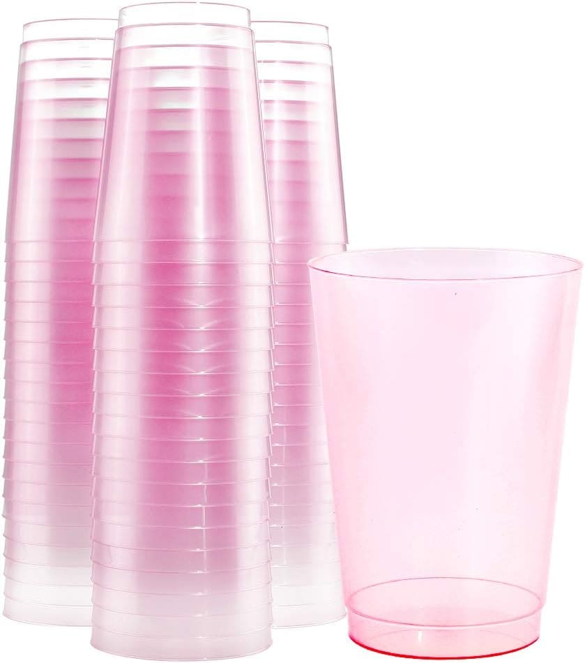 A stack of pink cups and a glass.