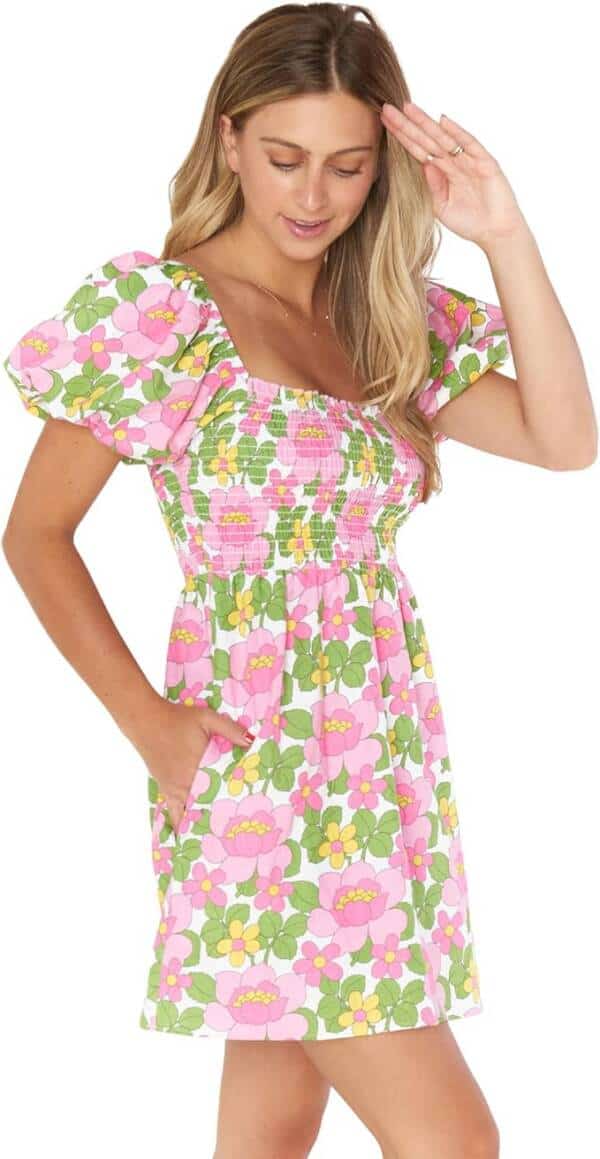 A woman in a pink and green floral dress.