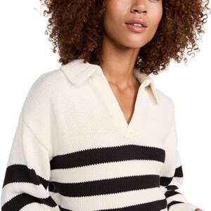 A woman with curly hair wearing a black and white striped sweater.