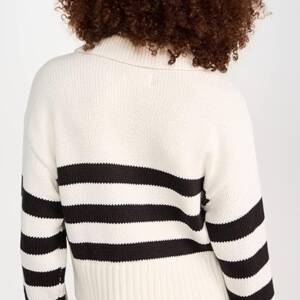 A woman wearing a white and black sweater.