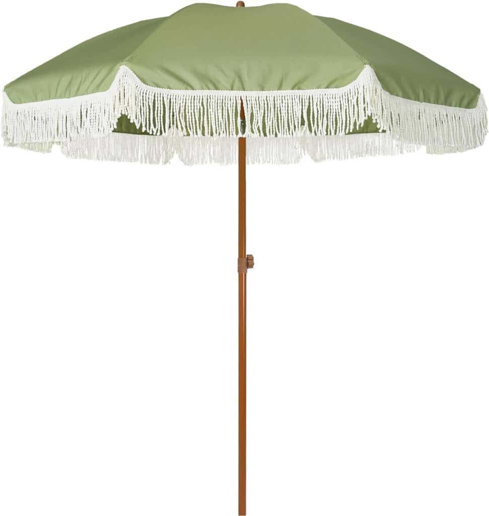 A green umbrella with white fringe on top of it.