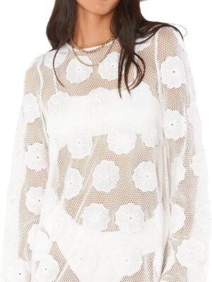 A woman wearing a white dress with flowers on it.