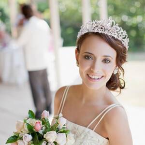 A bride with a tiara and bouquet of flowers.