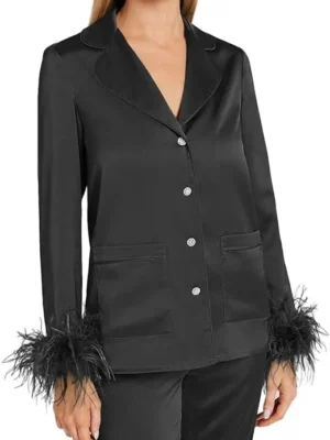 A woman wearing black pajamas with feathers on the sleeves.