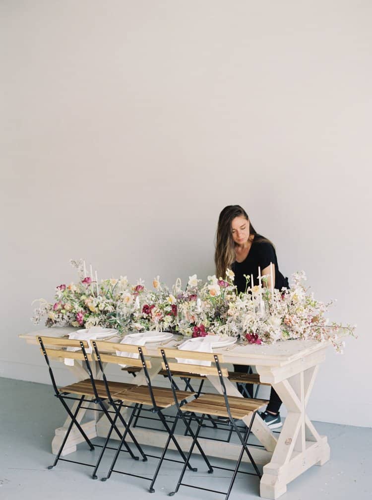 A woman sitting at the table with flowers on it