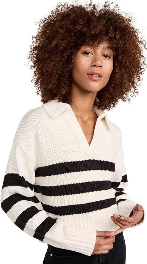 A woman with curly hair wearing a black and white striped sweater.