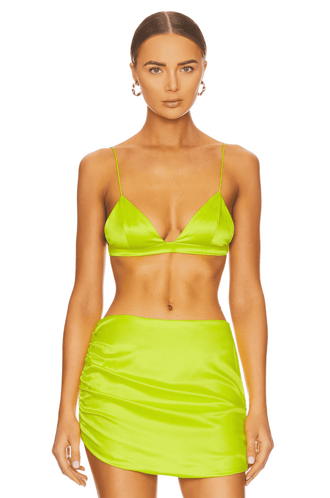A woman wearing a neon yellow skirt and bra.