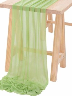 A wooden table with green curtains on it