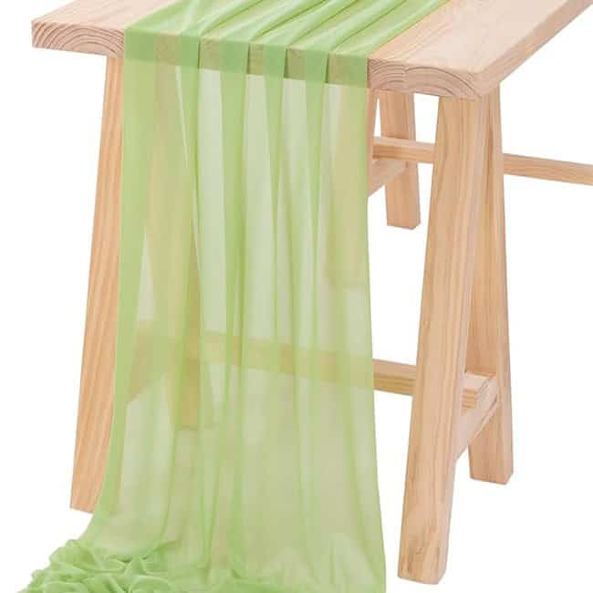 A wooden table with green curtains on it