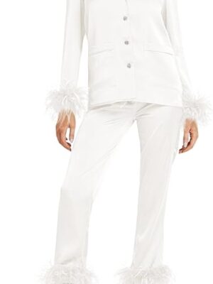 A woman in white suit standing on the side of the street.