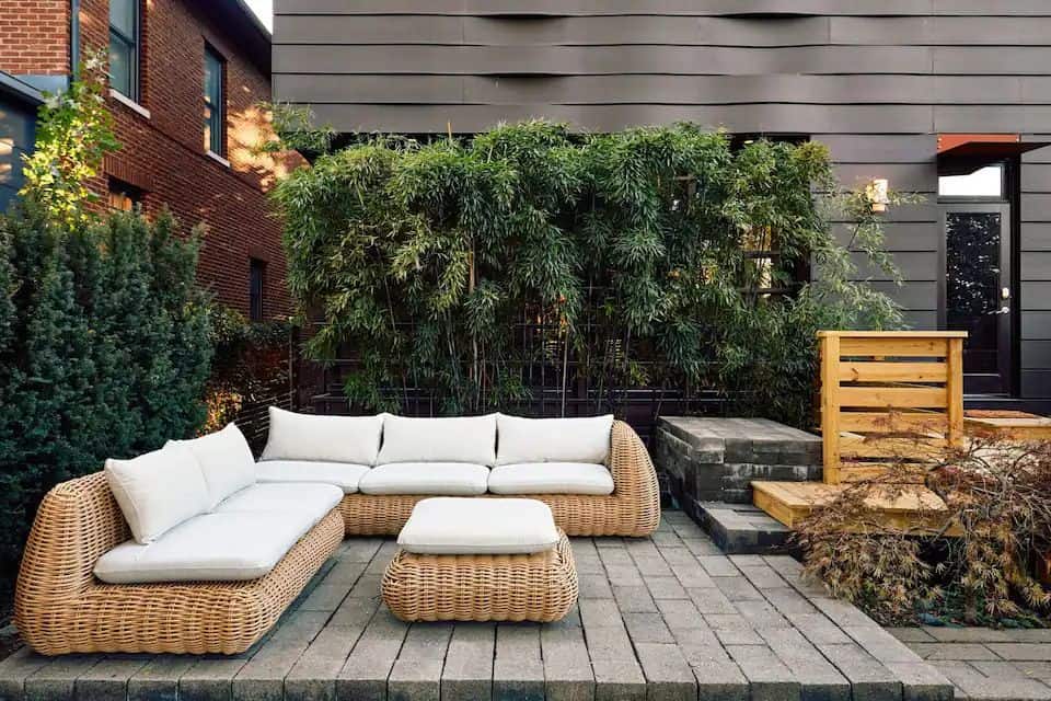 A patio with furniture and plants on the deck.