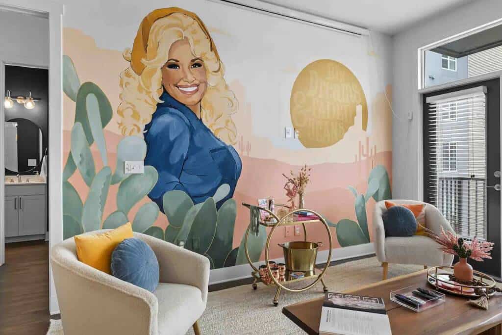 A living room with a painting of dolly parton on the wall.