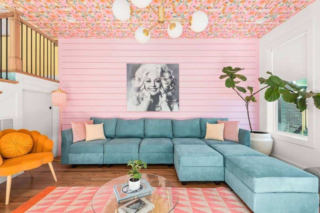 A living room with pink walls and blue furniture.