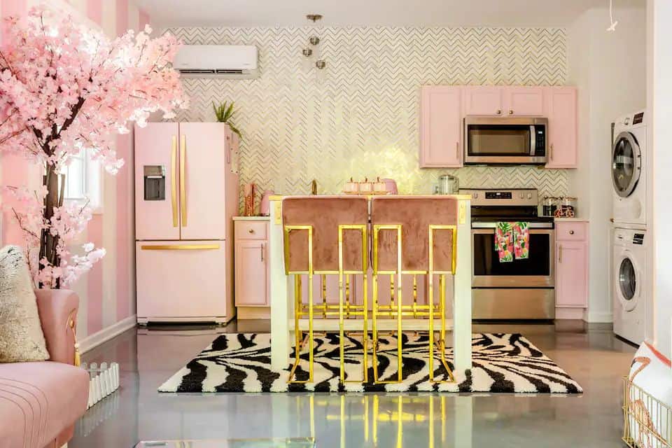 A kitchen with pink walls and zebra print rug.