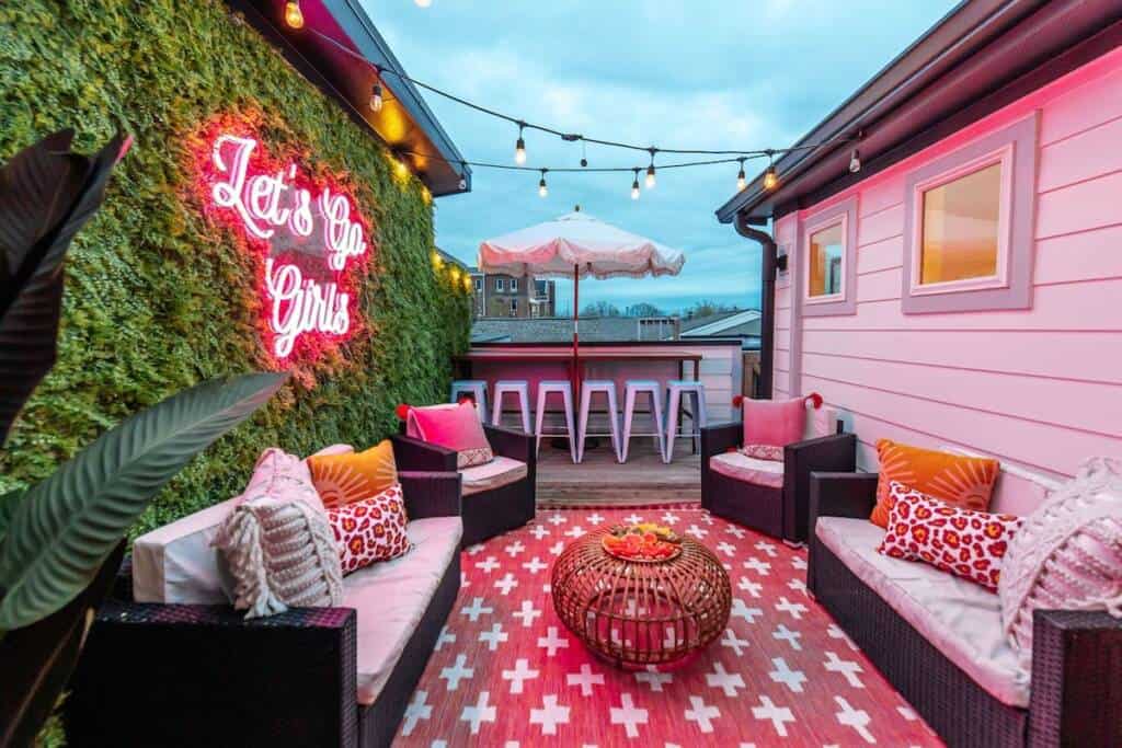 A patio with pink walls and a red rug.