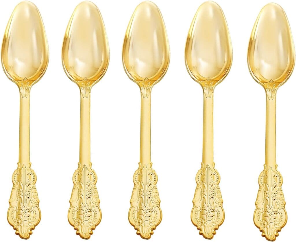 A group of five spoons that are gold colored.