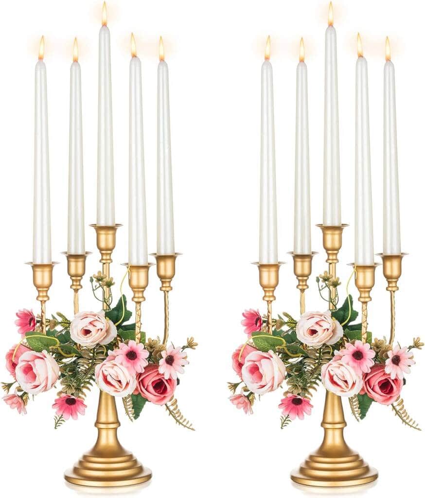 Two candles with flowers on them in a gold candlestick.