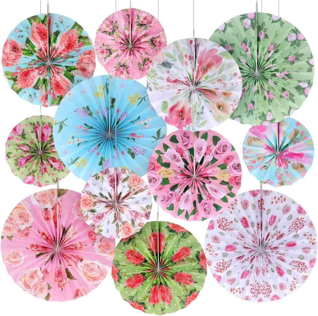 A bunch of paper fans hanging from strings