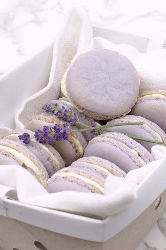 A close up of some purple cookies in a basket