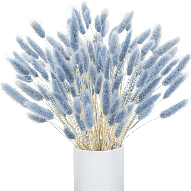 A white vase filled with blue flowers.